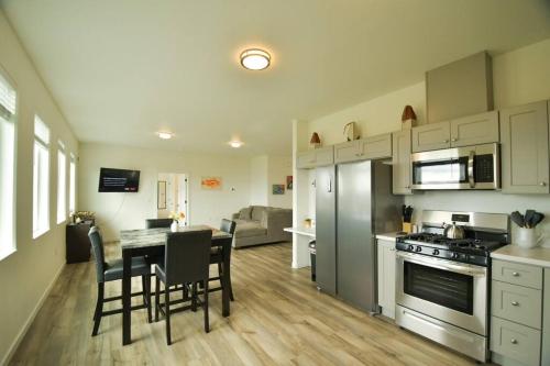 a kitchen and dining room with a table and appliances at Rockfish Retreat at Kachemak Bay Kabins in Homer