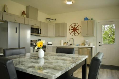 a kitchen with a table with a vase of flowers on it at Rockfish Retreat at Kachemak Bay Kabins in Homer