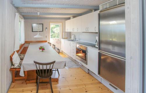 a kitchen with a table and a stainless steel refrigerator at Cozy Home In Samsø With Kitchen in Nordby