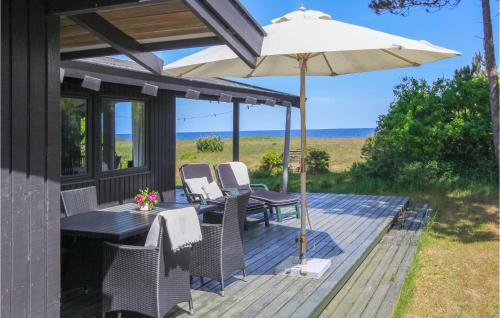 a patio with a table and an umbrella at Cozy Home In Samsø With Kitchen in Nordby