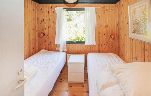 a bedroom with two beds and a window at Cozy Home In Samsø With Kitchen in Nordby