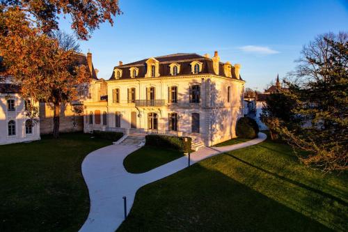 an old mansion with a pathway in front of it at Hôtel Chais Monnet & Spa in Cognac