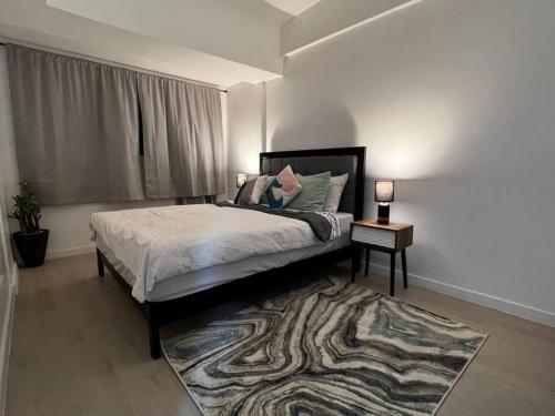 Schlafzimmer mit einem Bett mit einem Teppich und einem Fenster in der Unterkunft Haldis Suites in San Fernando