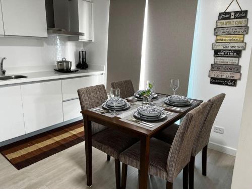 a dining room table with chairs and a kitchen at Haldis Suites in San Fernando