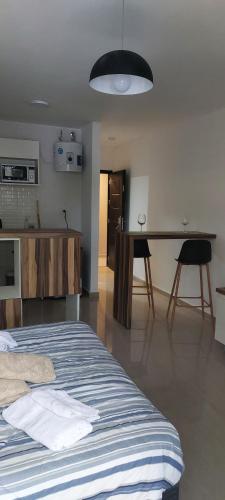 1 dormitorio con 1 cama y cocina con mesa en Alquiler Temporario Rosario 8 en Rosario