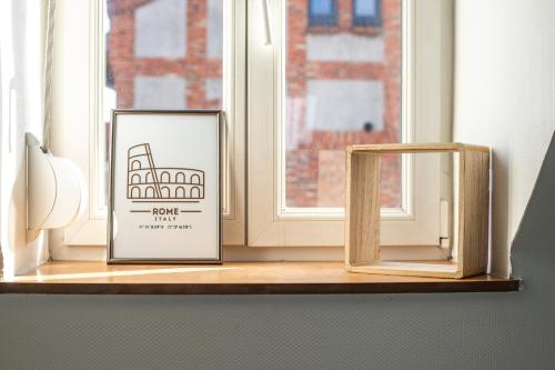 two signs sitting on a window sill next to a window at Casa Nostra - Arrière Gare in Arras