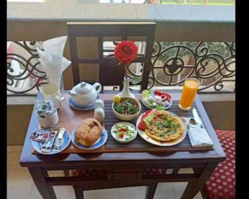 een ontbijttafel met eten en drinken op een balkon bij Queen Hotel Fayoum in Fayoum Center