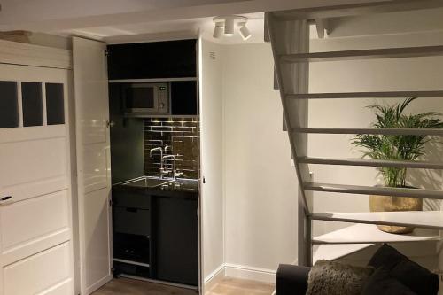 a kitchen with a stairs leading to a kitchen with a sink at Voorsterstaete former barn, including jacuzzi in Voorst