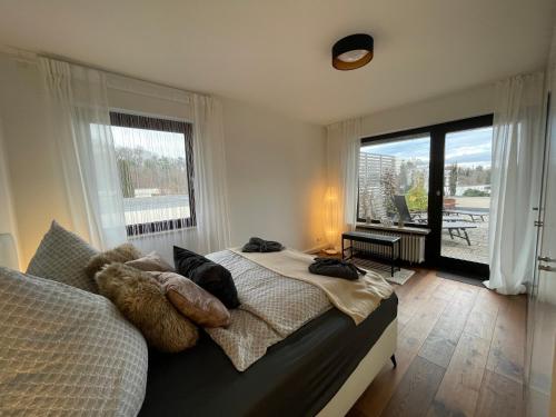 - une chambre avec un lit et une grande fenêtre dans l'établissement Sonnenterrasse mit Whirlpool, à Überlingen