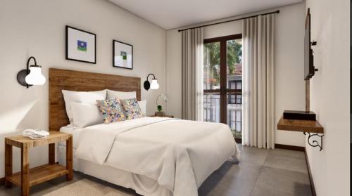 um quarto branco com uma cama grande e uma janela em Eco Resort Quinta Santa Bárbara em Pirenópolis