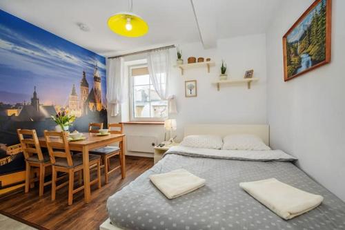 a bedroom with a bed and a dining room at Cosy Studio Apartment in Krakow
