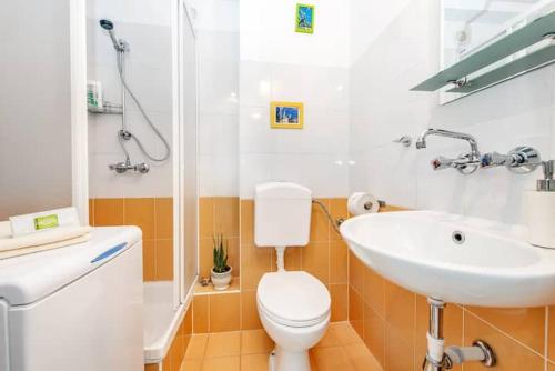 a bathroom with a white toilet and a sink at Cosy Studio Apartment in Krakow