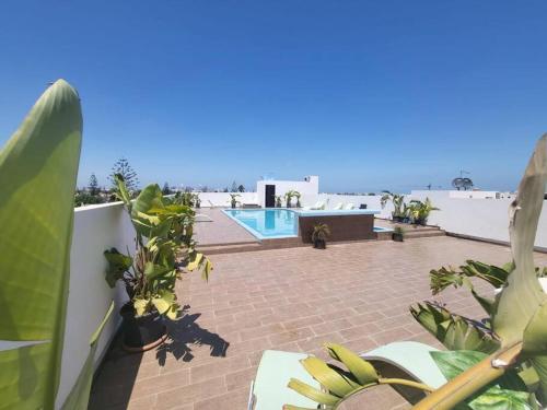 カサブランカにあるChez Miguel appartement Casablanca avec piscineの植物とスイミングプールのあるパティオの景色を望めます。
