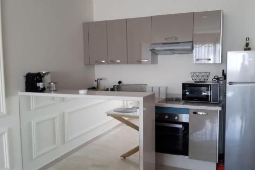 a kitchen with a counter and a microwave and a refrigerator at Chez Miguel appartement Casablanca avec piscine in Casablanca