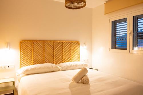 a bedroom with a white bed with a yellow headboard at KALIMA APARTMENT in Puerto del Carmen