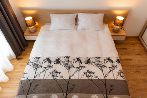 sypialnia z łóżkiem z dwoma lampami na dwóch stołach w obiekcie Pastel Apartments w Braszowie
