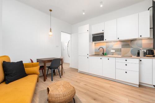 a kitchen and living room with a couch and a table at Apartament Plac Konstytucji by Your Freedom in Warsaw