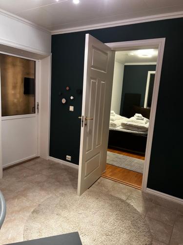 a room with a door and a bedroom with a bed at Liten kjellerleilighet. Landlig rolig område. in Tromsø