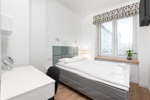 een slaapkamer met 2 bedden en een raam bij Apartament Plac Konstytucji by Your Freedom in Warschau