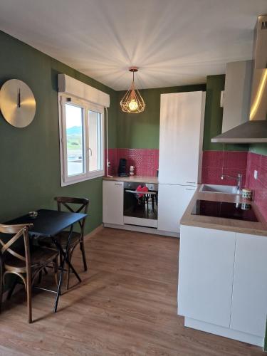 une cuisine avec une table et une salle à manger dans l'établissement Studio Climatisé Parking Gratuit, à Sarrola-Carcopino