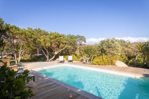 - une piscine avec 2 chaises à côté dans l'établissement Terra di sole, à Pianottoli-Caldarello