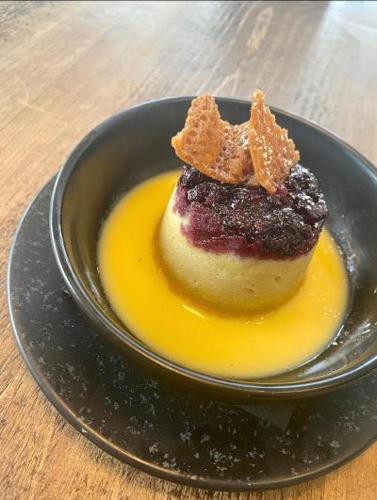 a dessert on a black plate on a table at Woodcote Hotel in Hooton