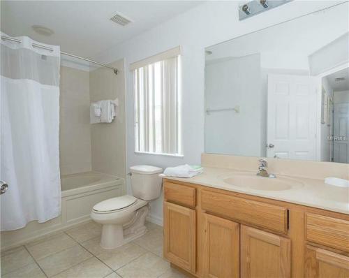 uma casa de banho com um WC, um lavatório e um chuveiro em Gold Corvette em Kissimmee