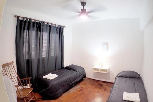 a bedroom with a black bed and a window at Departamento Bouquet in Barraquero