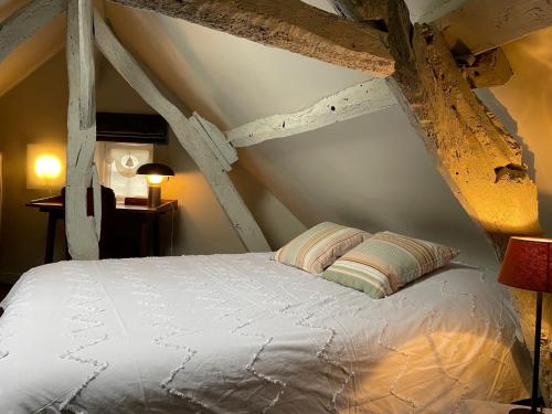 een slaapkamer met een wit bed op een zolder bij La maison St Jean in Honfleur