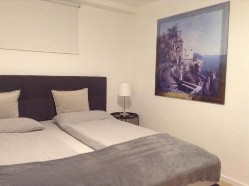 um quarto com uma cama e um quadro na parede em EBH HOME em Filderstadt