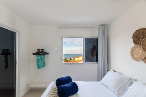 Habitación blanca con cama y ventana en Tríplex para 9 pessoas na cobertura do Pirangi Prime por Carpediem en Parnamirim