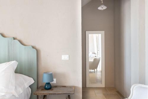 a bedroom with a bed and a table with a blue lamp at RoccaSeta in Scicli