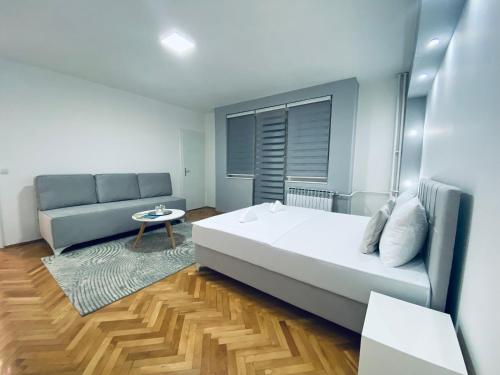 um quarto com uma cama grande e um sofá em A Apartment Visegrad em Višegrad