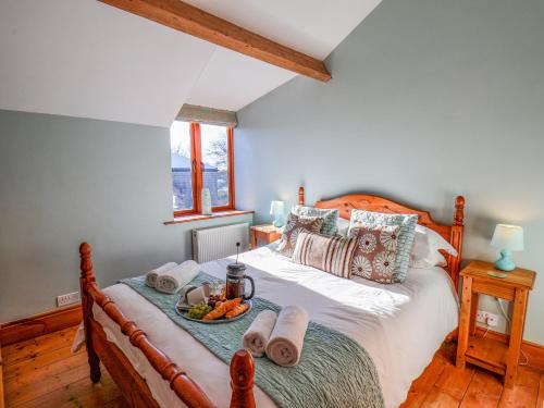a bedroom with a bed with a tray of food on it at Hayloft Cottage in Staintondale