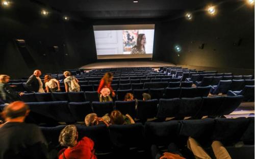 un groupe de personnes assises dans un auditorium en train de regarder un écran dans l'établissement Centre ville Foirail APPART EVASION - Studio N°1, à Pau