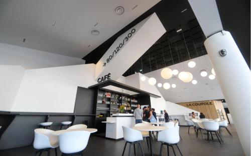 un restaurant avec des tables et des chaises blanches et un comptoir dans l'établissement Centre ville Foirail APPART EVASION - Studio N°1, à Pau