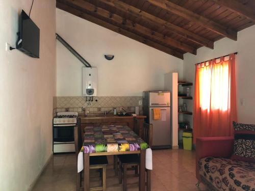 a kitchen with a table and a kitchen with a couch at Los Manzanos in Villa Ciudad Parque
