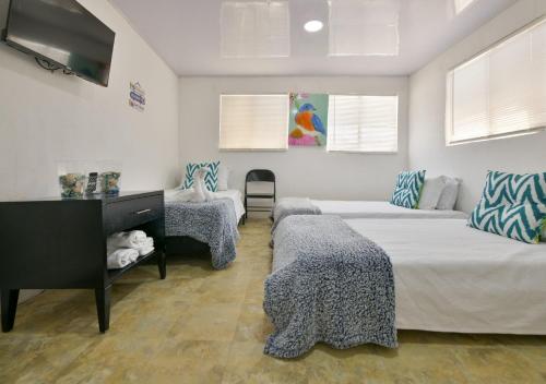 a living room with two beds and a tv at Bay Winds Inn in San Andrés