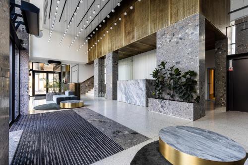 a lobby of a building with a table and benches at Dream Apartment Portova Gdynia in Gdynia