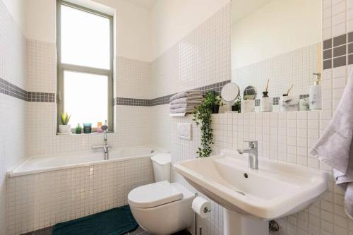 La salle de bains blanche est pourvue d'un lavabo et de toilettes. dans l'établissement Luxueux appart proche de gare du Midi, à côté du Centre Ville, à Bruxelles