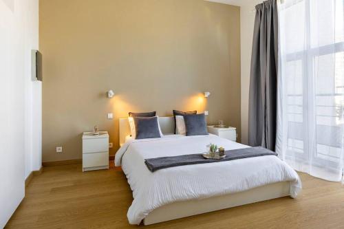 a bedroom with a large bed and a large window at Bel appart proche de gare du Midi, à côté du Centre Ville in Brussels