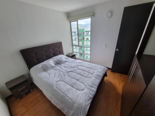 a bedroom with a large bed with a large window at Cómodo y acogedor apartamento in Pasto