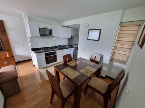 cocina y comedor con mesa y sillas en Cómodo y acogedor apartamento, en Pasto