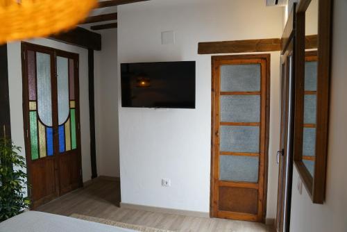Habitación con TV y puerta con ventana. en Coqueta Casita de Pescadores frente al Puerto en Dénia
