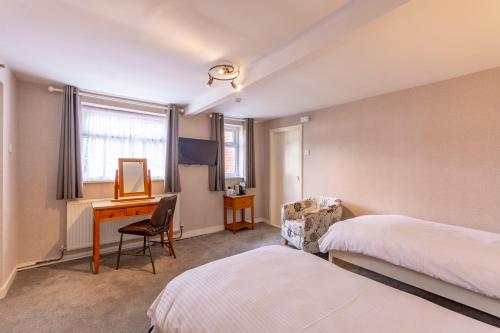 a hotel room with a desk and a bed at Woodcote Hotel in Hooton