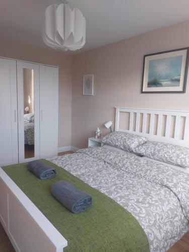 a bedroom with a large bed with two pillows on it at Cosy one bed apartment in Carnlough in Ballymena