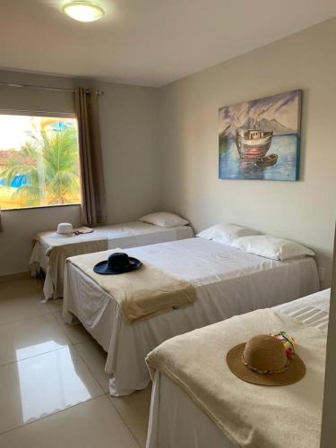 a room with three beds with hats on them at JL Temporadas q 222 PortobelloPark in Porto Seguro