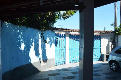 a building with blue doors and a car parked in front at Casa de Praia em Mongaguá in Mongaguá