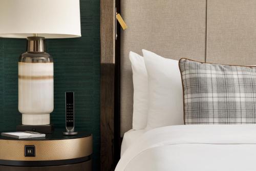 a bedroom with a bed and a lamp on a table at Fairmont Banff Springs in Banff
