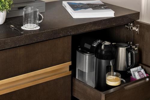 a cupboard with a coffee maker on a counter at Fairmont Banff Springs in Banff